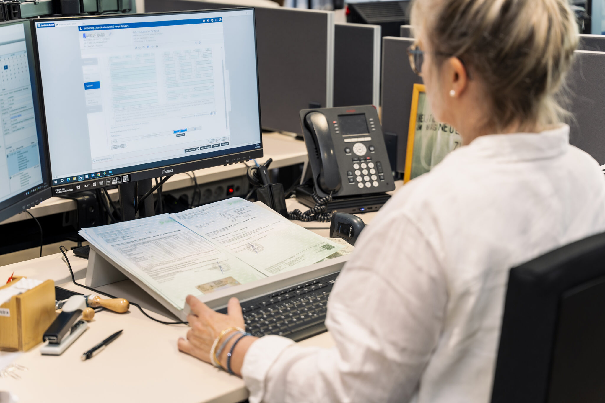 Mitarbeiterin in der Zulassungsstelle am Arbeitsplatz