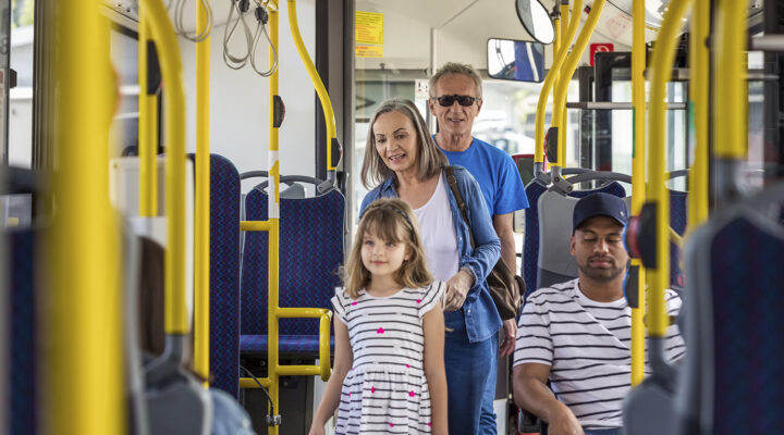 Älterer Mann und ältere Frau reisen mit ihrer Enkelin. Das Seniorenpaar ist mit ihrem Enkelkind im Bus. Sie befinden sich in öffentlichen Verkehrsmitteln.