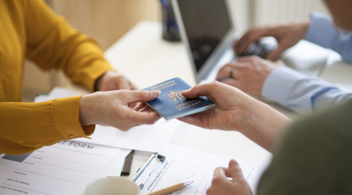 Woman and man volunteers helping ukrainian woman to fill in forms at asylum centre.