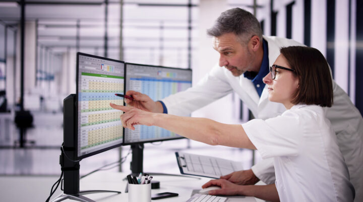 Gesundheitsamtmitarbeiter und Mitarbeiterin schauen sich eine Exel-Tabelle an