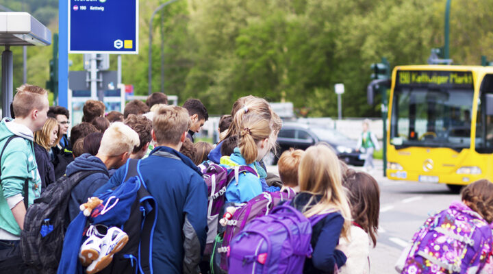 Schüler*innen warten und schauen nach dem Schulbus