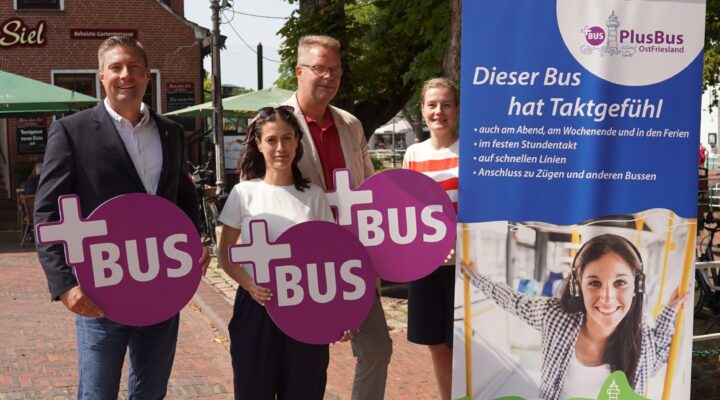 Gruppe von Menschen in Greetsiel, mit Schildern vom PlusBus in der Hand